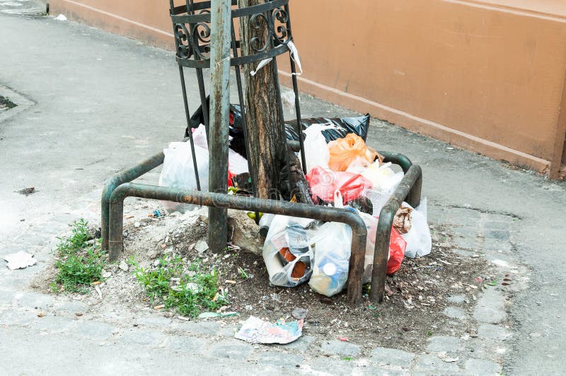 Big two metal dumpster garbage cans full of overflow litter and junk  polluting the street in the city Stock Photo