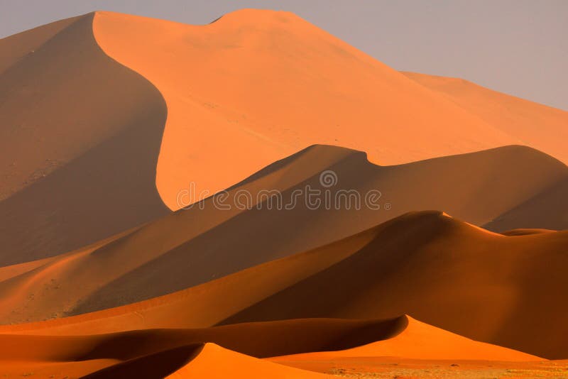 Big orange dune with blue sky and clouds, Sossusvlei, Namib desert, Namibia, Southern Africa. Red sand, biggest dun in the world.