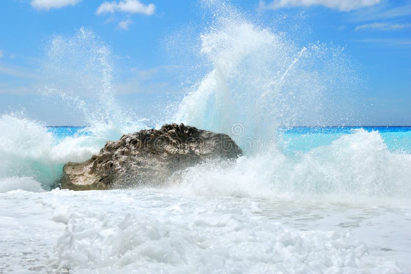 Big sea wave breaking on the shore rocks