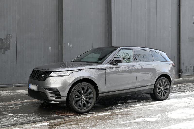 Big silver grey British 4WD compact luxury crossover car Range Rover Velar parked in ice and snow