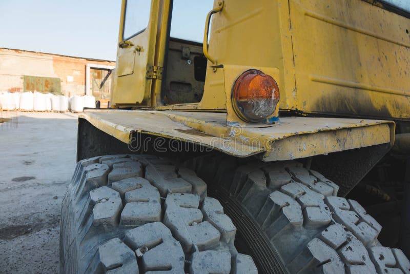 Big Spiked Wheels of Yellow Tractor Durable Rubber Tires Stock Photo