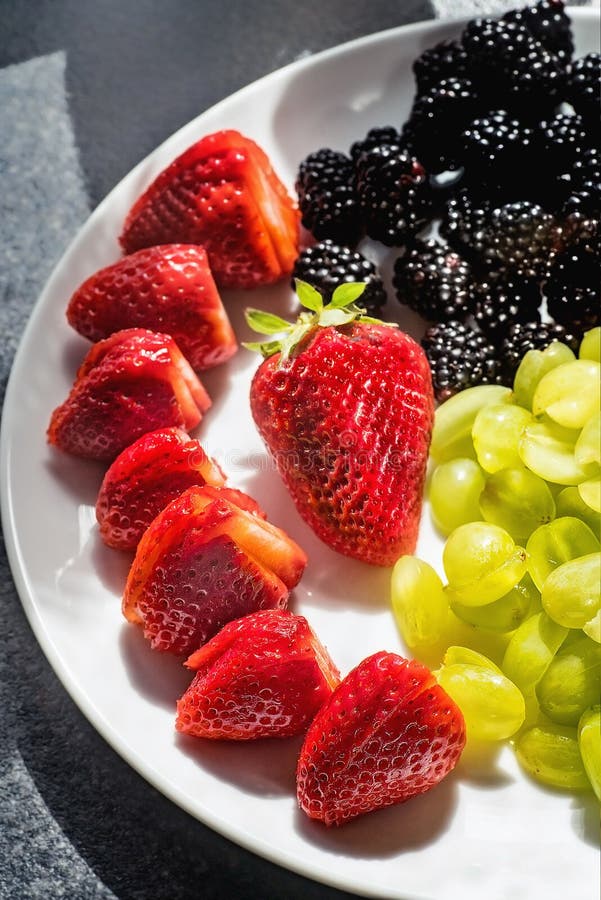 Big Strawberries, Blackberries and Grapes on a White Plate Stock Photo
