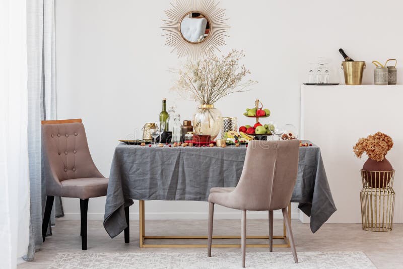 Big stylish glass vase with dry flowers on dining table set for birthday party