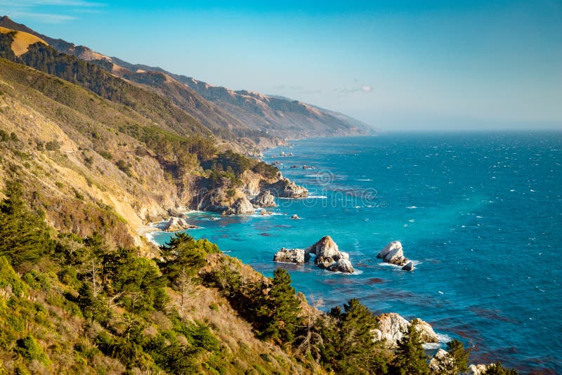 Scenic view of the rugged coastline of Big Sur with Santa Lucia Mountains along famous Highway 1 illuminated in beautiful golden evening light at sunset in summer, California Central Coast, USA. Scenic view of the rugged coastline of Big Sur with Santa Lucia Mountains along famous Highway 1 illuminated in beautiful golden evening light at sunset in summer, California Central Coast, USA