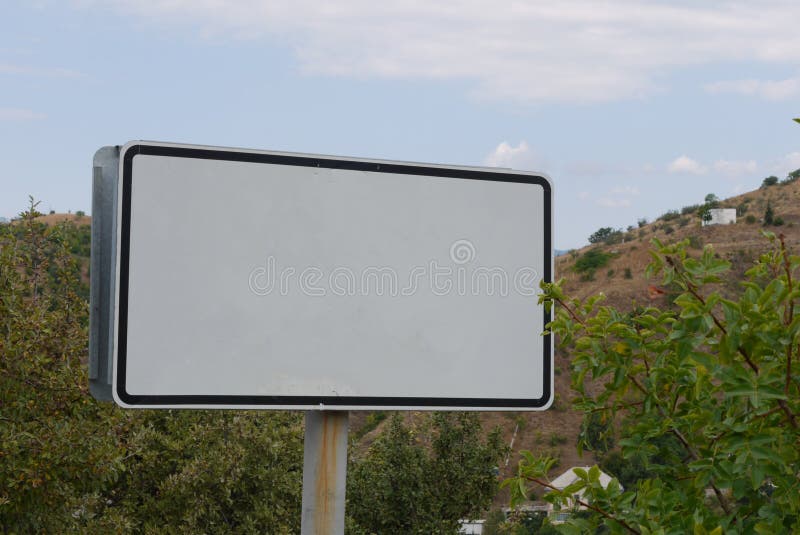 Big white billboard on a background of a gentle blue sky.