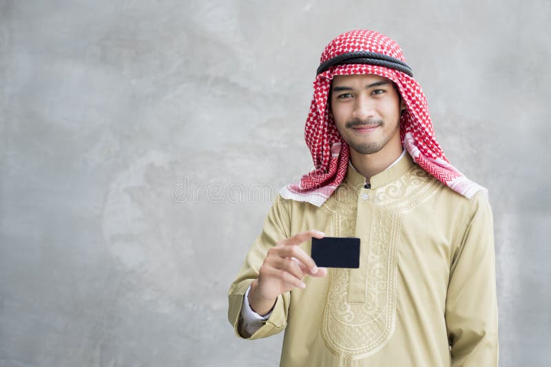 Biglietto da visita arabo bello sorridente della tenuta dell'uomo fotografia stock libera da diritti Biglietto da visita arabo bello sorridente della tenuta dell'uomo fotografia stock libera da diritti