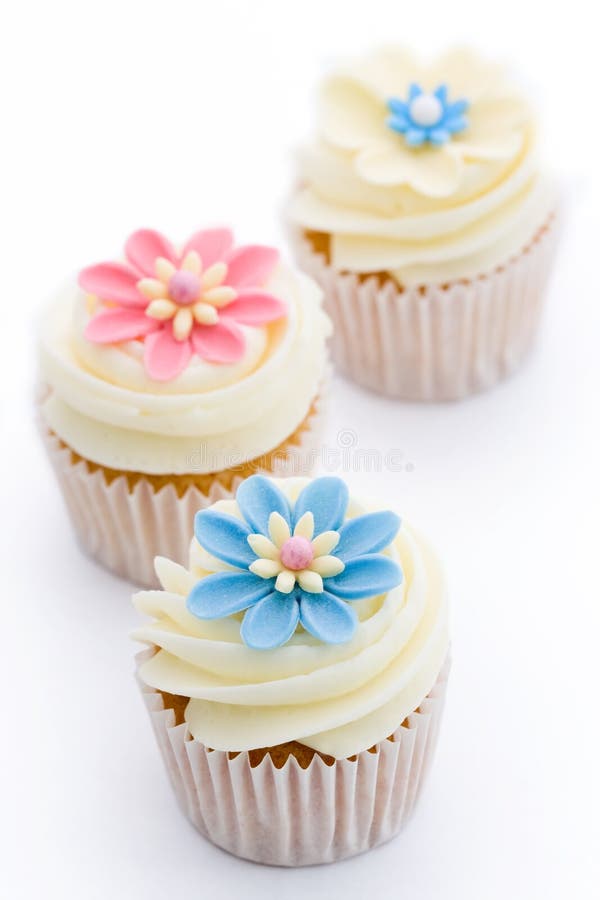Three flower cupcakes isolated against white. Three flower cupcakes isolated against white