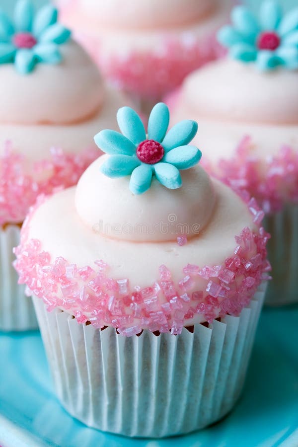 Cupcakes decorated with pink frosting and sugar flowers. Cupcakes decorated with pink frosting and sugar flowers