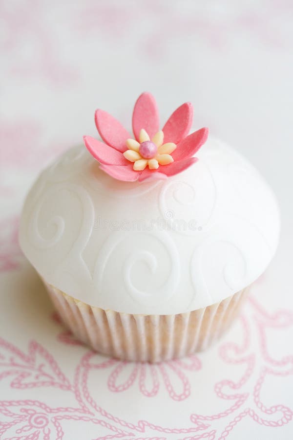 Cupcake decorated with embossed fondant and a pink sugar flower. Cupcake decorated with embossed fondant and a pink sugar flower