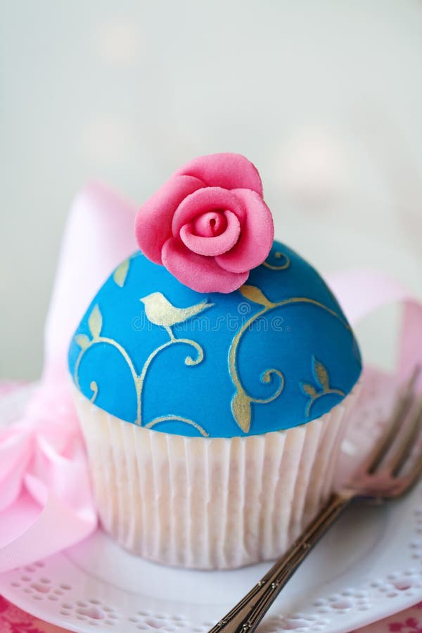 Cupcake decorated with gold embossing and a sugar rose. Cupcake decorated with gold embossing and a sugar rose