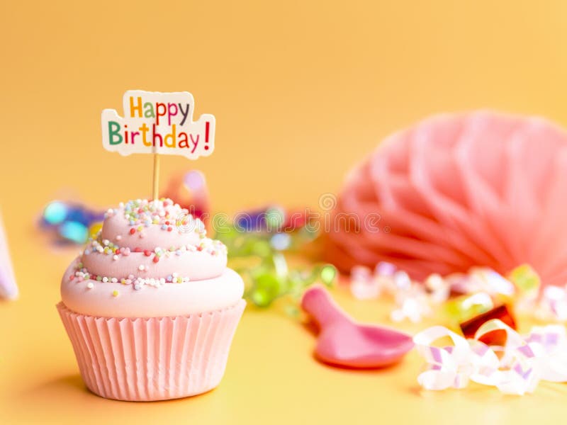 Bigné rosa con il testo di buon compleanno su fondo beige fotografie stock Bigné rosa con il testo di buon compleanno su fondo beige fotografie stock