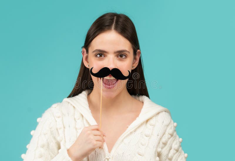 Bigote y feliz con el apoyo. Retrato de mujer cómica. Cara divertida con bigote en el palo. Mujer divertida sosteniendo bigote de imagenes de archivo