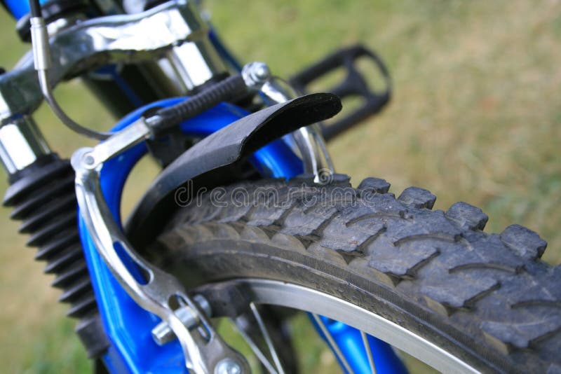 Close-up of mountain bike wheel on green background.