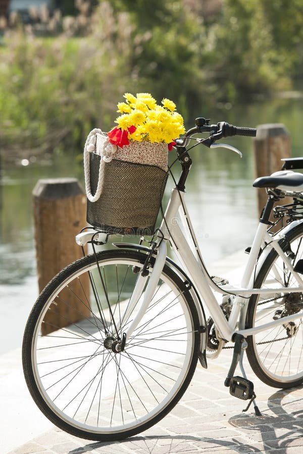 Vintage Yellow Bike With A Basket With Flowers Stands Near The Cafe Of