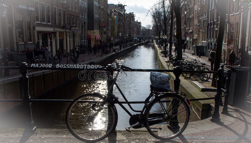 Bike en el puente en Amsterdam con el fondo del canal imágenes de archivo libres de regalías Bike en el puente en Amsterdam con el fondo del canal imágenes de archivo libres de regalías