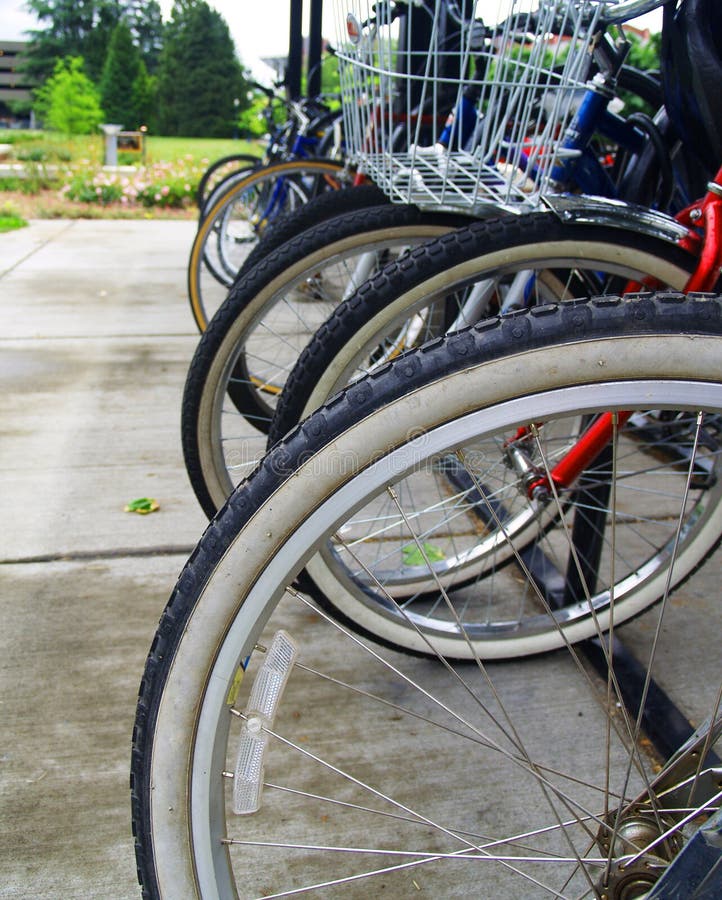 A group of bikes locked precariously on a bike rack