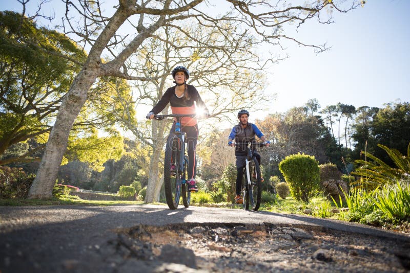 Biker couple cycling on the countryside road stock photo Biker couple cycling on the countryside road stock photo