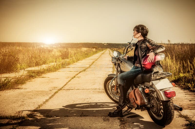 Biker ragazza si siede su una moto.