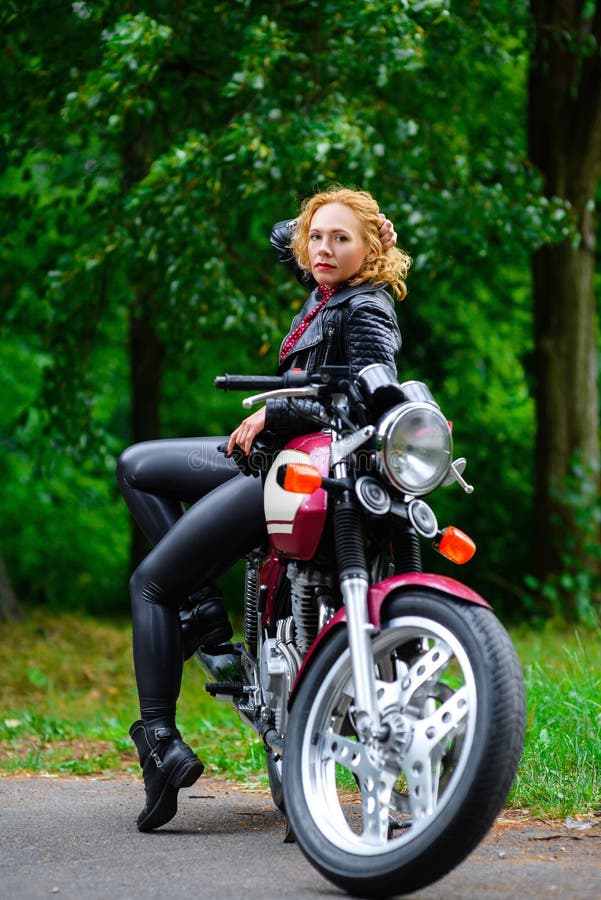 Biker girl in leather jacket on a motorcycle