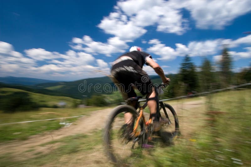 Biciclist în albastru de mișcare stock image