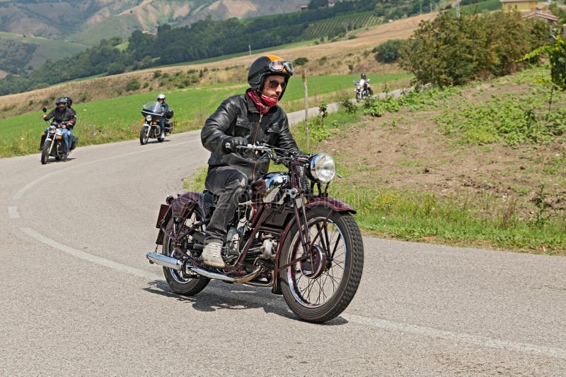 Biker rides an old Moto Guzzi of the thirties