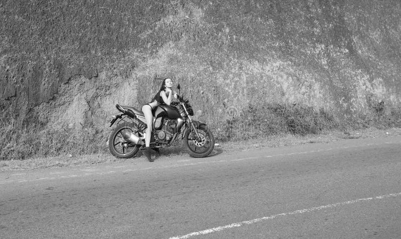 Biker theme: beautiful woman with body posing with motorbik