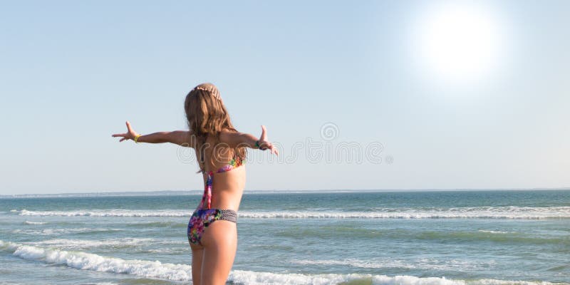 Bikini body woman sun tanning relaxing on perfect tropical beach and turquoise ocean water in fashion swimwear