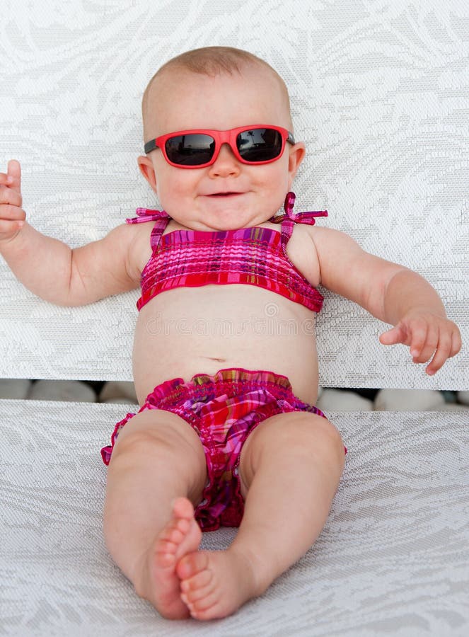 Baby girl with sunglasses smiling in pink bikini. Baby girl with sunglasses smiling in pink bikini