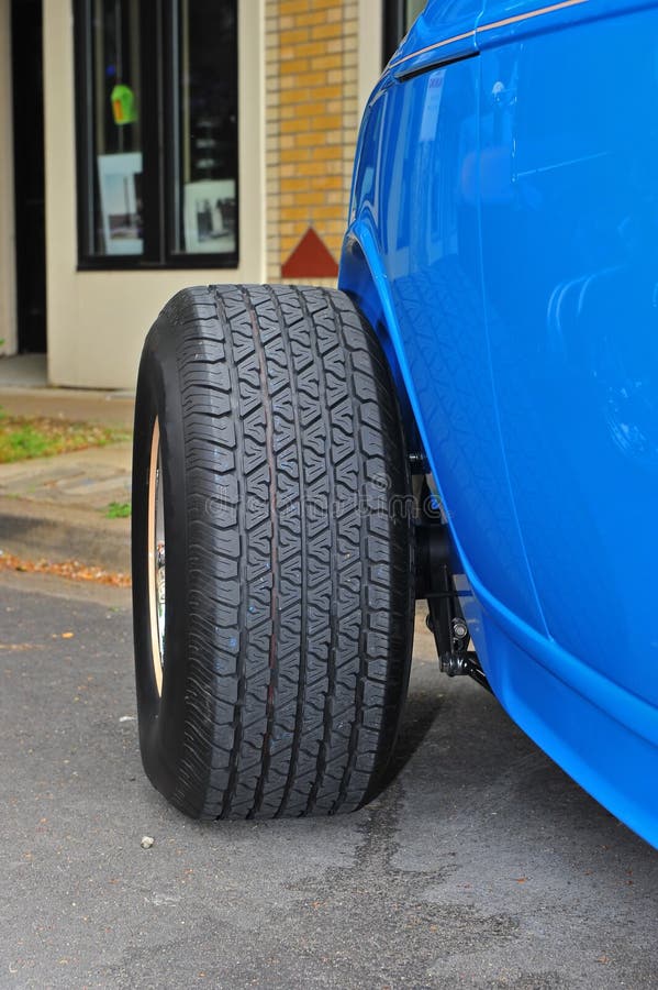 Abstract of a shiny blue restored 50's era sports car rear tire. Abstract of a shiny blue restored 50's era sports car rear tire.