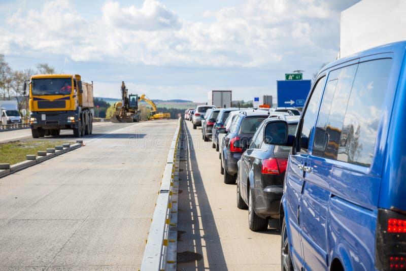 Bilar ställer upp på vägkonstruktionen för motorvägen tack vare royaltyfri foto Bilar ställer upp på vägkonstruktionen för motorvägen tack vare royaltyfri foto