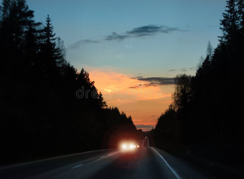 Approaching car headlights glare on evening road. Approaching car headlights glare on evening road