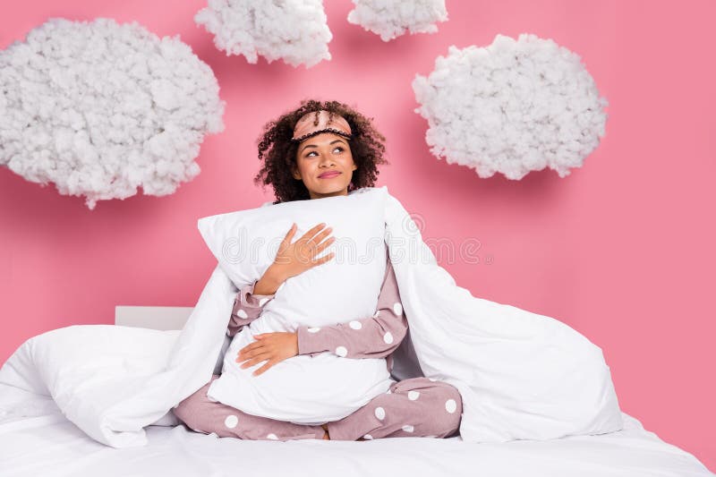 Photo of excited dreamy lady wear pajama smiling cuddling pillow looking fluffy clouds isolated pink color background. Photo of excited dreamy lady wear pajama smiling cuddling pillow looking fluffy clouds isolated pink color background.