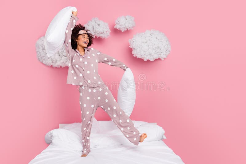 Photo of funky cheerful lady wear pajama enjoying pillow fight isolated pink color background. Photo of funky cheerful lady wear pajama enjoying pillow fight isolated pink color background.