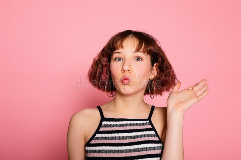 Bild av en ung, glad, vacker kvinna som står isolerad över rosa arkivfoto