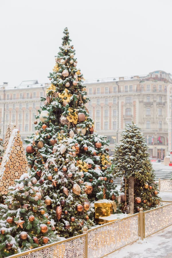 Bild av julgranar från Moskva utomhus med kulor och festljus täckta med snö, med selektiv fokus i bakgrunden arkivbild Bild av julgranar från Moskva utomhus med kulor och festljus täckta med snö, med selektiv fokus i bakgrunden arkivbild
