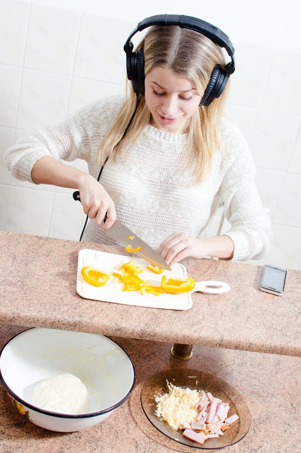 Bild der schönen blonden netten jungen Frau mit Kopfhörern hörend Musik, die Pizzaporträt macht stockfotografie Bild der schönen blonden netten jungen Frau mit Kopfhörern hörend Musik, die Pizzaporträt macht stockfotografie