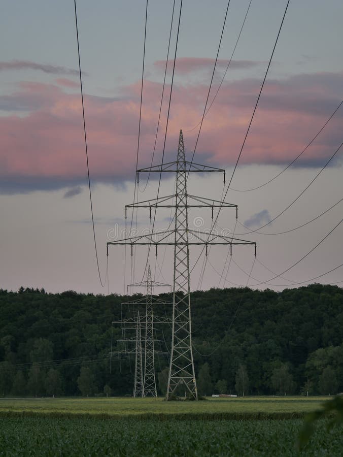 Bild der Stromleitung während des Sonnenuntergangs mit Kraftwerk stockbilder Bild der Stromleitung während des Sonnenuntergangs mit Kraftwerk stockbilder