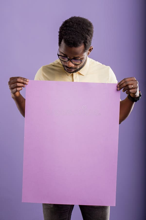 Bild des jungen Afroamerikanermannes, der leeres Brett auf violettem Hintergrund h?lt stockbild Bild des jungen Afroamerikanermannes, der leeres Brett auf violettem Hintergrund h?lt stockbild