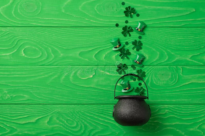 Bild från översiktsfoto av helfärgade patricks dagdekorationer schampetti och små leprechaun-hattar som flyger ut från potten på i royaltyfri fotografi
