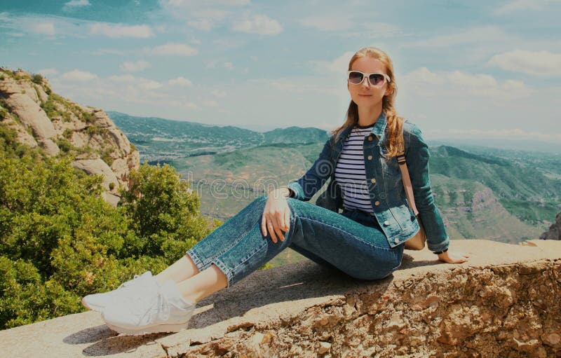 Bild på resande unga kvinnor som sitter på stenar på montserråttbakgrund i bergsområden arkivfoto