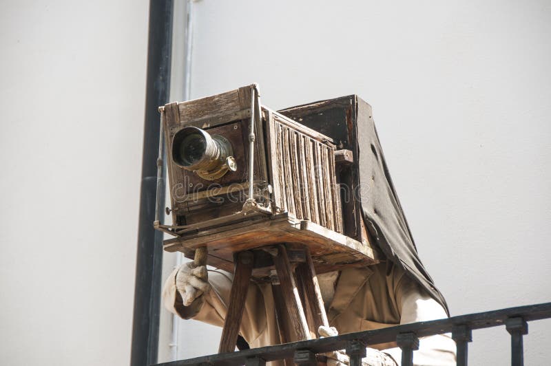 Bilden av en man som tar bilder på en gammal kamera på en stativ arkivbilder Bilden av en man som tar bilder på en gammal kamera på en stativ arkivbilder