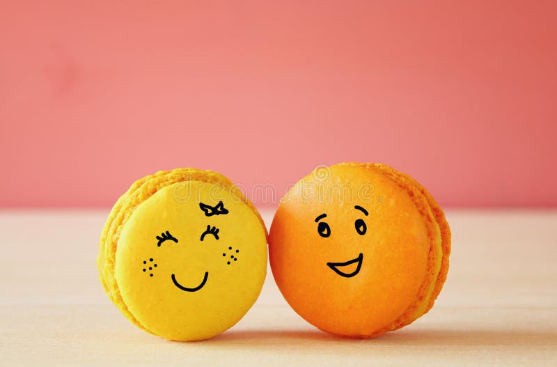 Bilden av två gulliga makron med utdragen smiley vänder mot arkivbild