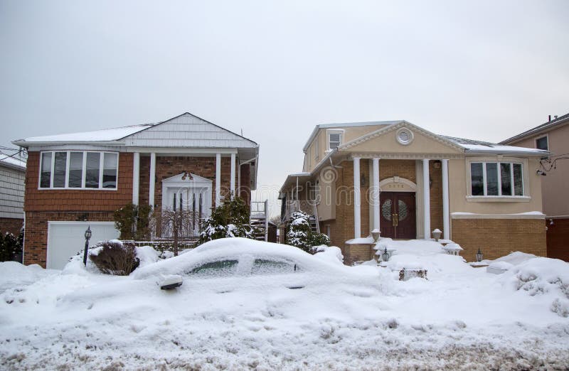 Bilen och huset under snö efter massiva vinterstormar slår nordost