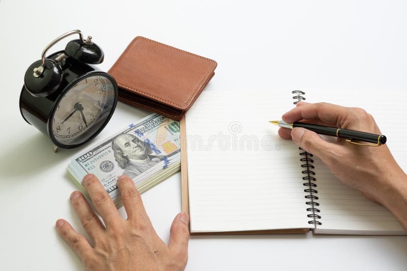 Billet de banque du dollar en dehors de portefeuille brun sur le carnet photo stock Billet de banque du dollar en dehors de portefeuille brun sur le carnet photo stock