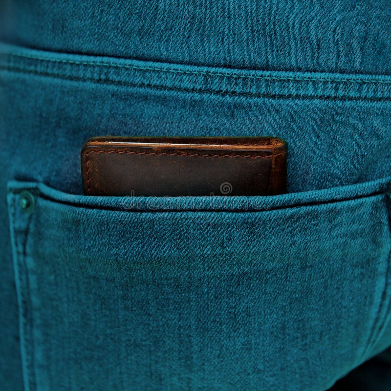 Billetera masculina marrón de cuero genuino de alta calidad yace en el bolsillo posterior de los vaqueros azules de los hombres, imagenes de archivo Billetera masculina marrón de cuero genuino de alta calidad yace en el bolsillo posterior de los vaqueros azules de los hombres, imagenes de archivo