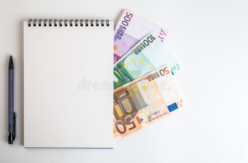 Euro currency banknotes and notepad with pen isolated on white background. European money cash of 50, 100, 500 euros bills, top view, flat lay. Euro currency banknotes and notepad with pen isolated on white background. European money cash of 50, 100, 500 euros bills, top view, flat lay