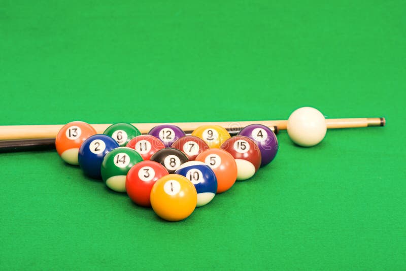 Billiard balls arranged on a green pool table