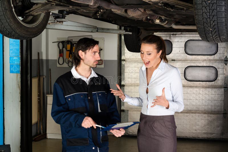 Car mechanic with attractive but angry female customer going through maintenance checklist in garage - apparently the efforts are overpriced since the women is screaming at the mechanic. Car mechanic with attractive but angry female customer going through maintenance checklist in garage - apparently the efforts are overpriced since the women is screaming at the mechanic.