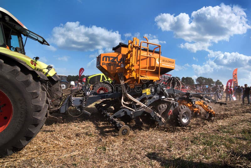 Bilogirya, Khmelnytsky region, UKRAINE - August 19, 2021: Farmers preparing the land and fertilizing and sowing Tractor with