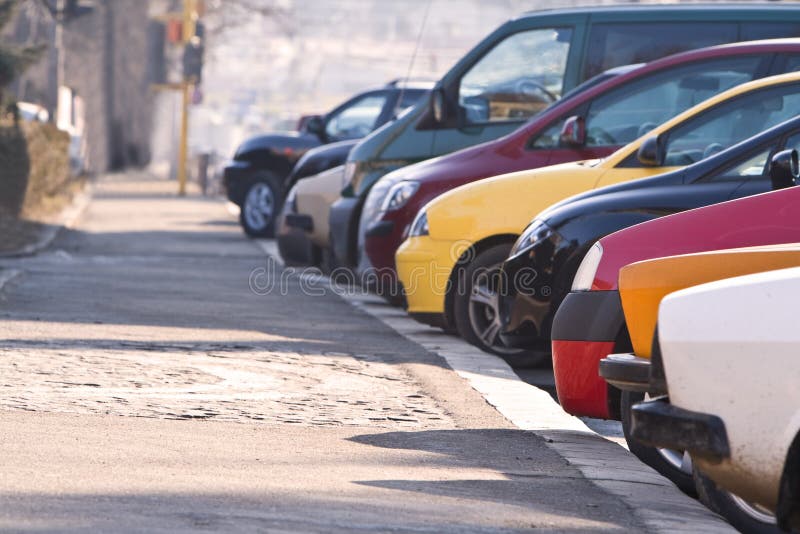 Row of different cars parked in a crowded city. Row of different cars parked in a crowded city.